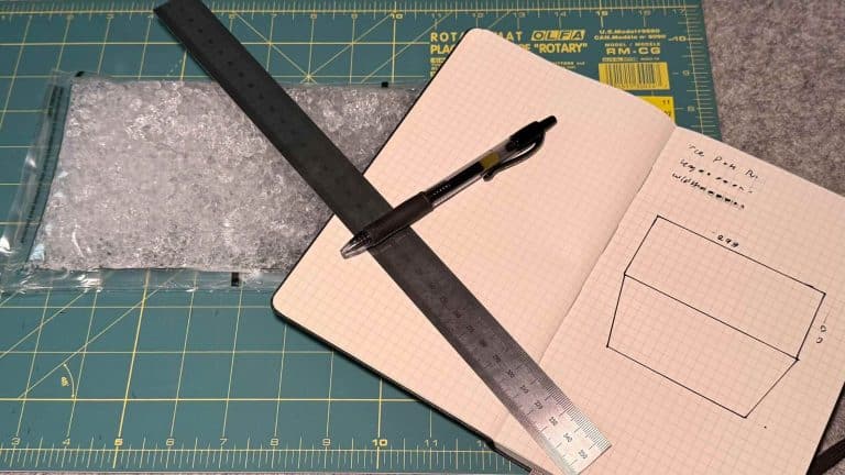 Planning materials for  MYOG Sewing projects: an object, a metric ruler, a notebook, and pen