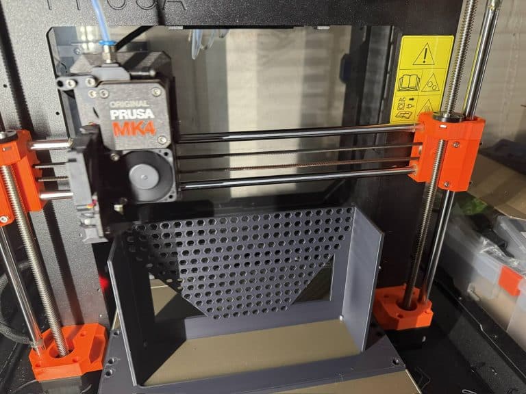 3D printing a custom 10 inch rack mount using OpenSCAD, captured mid-print on a textured bed — a hands-on MYOG project for a personalized homelab setup.