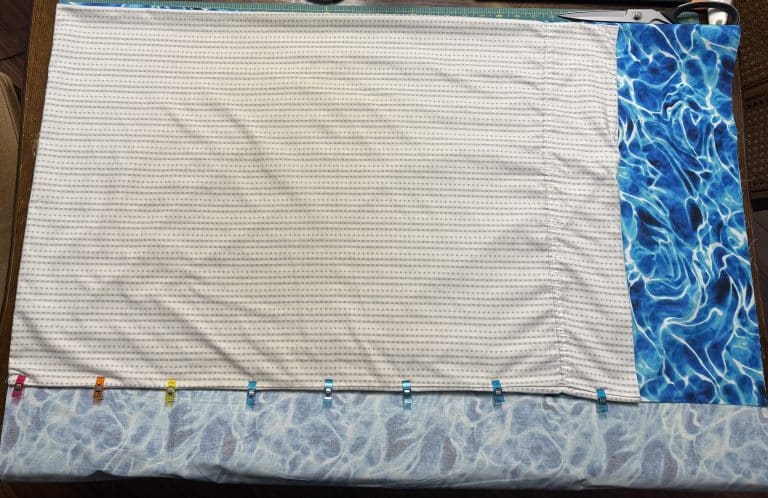 Fabric laid out on a table with a pillow case being used as a reference.